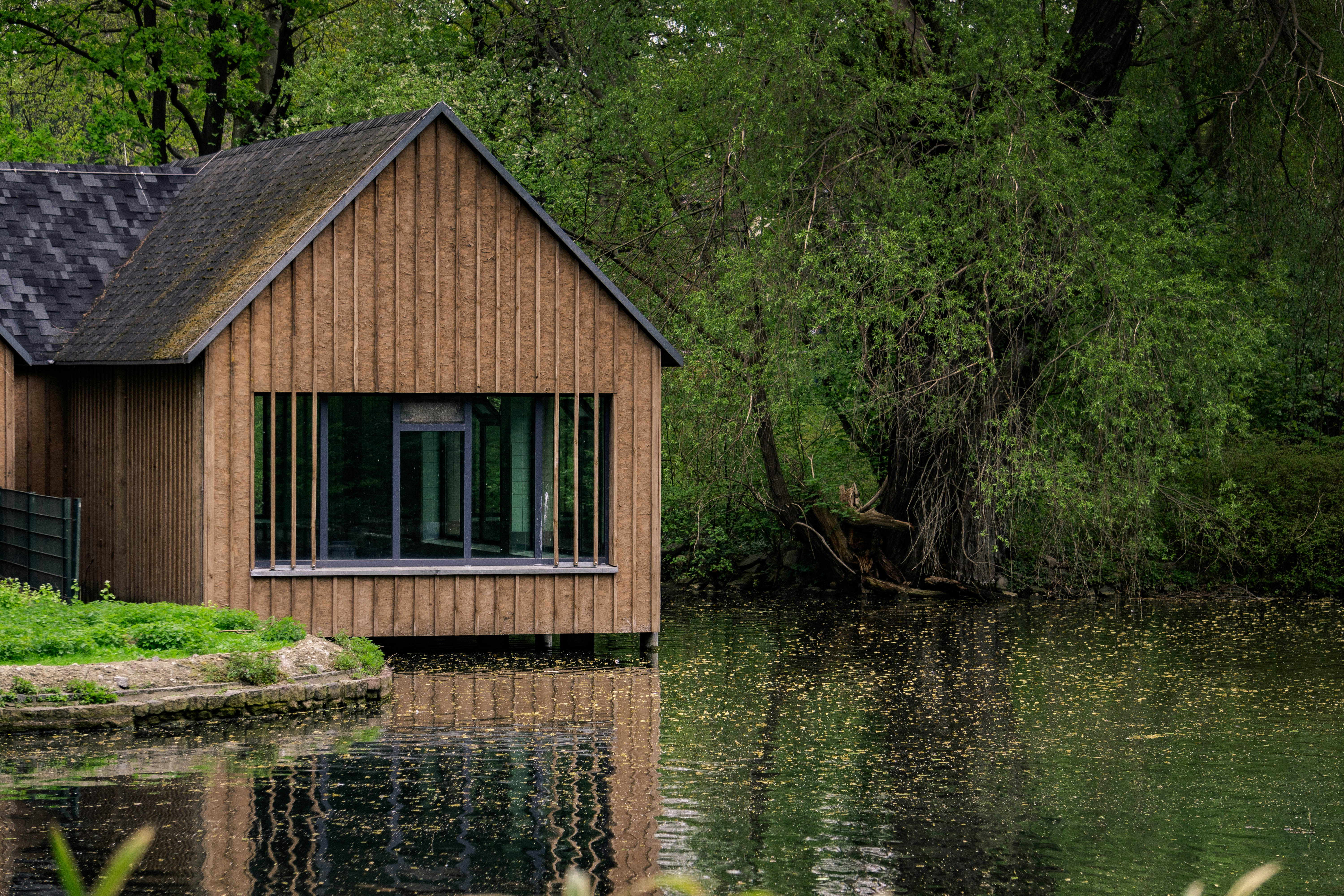 brown wooden cabin near river at daytime